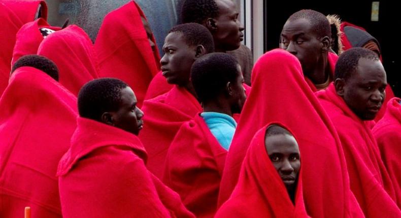 A group of migrants cover themselves with blankets following their arrival on board of a Spanish coast guard vessel into the southern Spanish port of Malaga on December 3, 2016