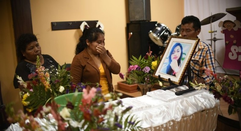 Marta Lidia Garcia (C) cries by the coffin of her 17-year-old daughter, Siona Hernandez, who died in a fire at a state-run shelter, during the wake on March 10, 2017, south of Guatemala City