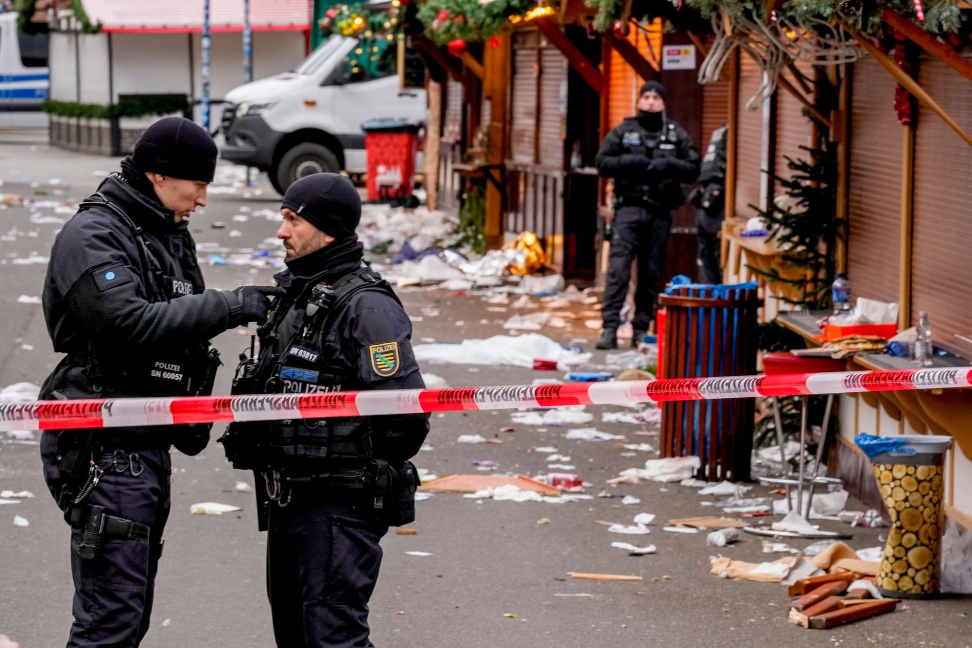 Policajti strážia vianočný trh v Magdeburgu, kde v piatok 20. decembra večer do davu ľudí vrazilo auto.