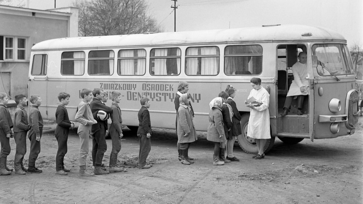 Dzieci oczekujące na badanie zębów przed objazdowym gabinetem stomatologicznym, mieszczącym się w autobusie Związkowego Ośrodka Lekarsko-Dentystycznego