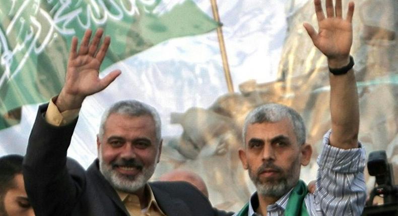 Freed Palestinian prisoner Yahya Sinwar (R), a founder of Hamas' military wing, and then Hamas leader Ismail Haniya wave as supporters celebrate the release of prisoners in Khan Yunis, southern Gaza Strip on October 21, 2011