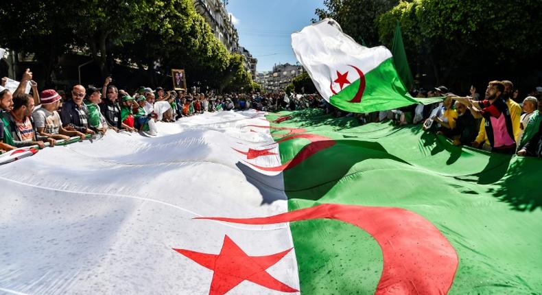 Algerian protesters march with a giant national flag during a demonstration in the capital Algiers on May 31, 2019