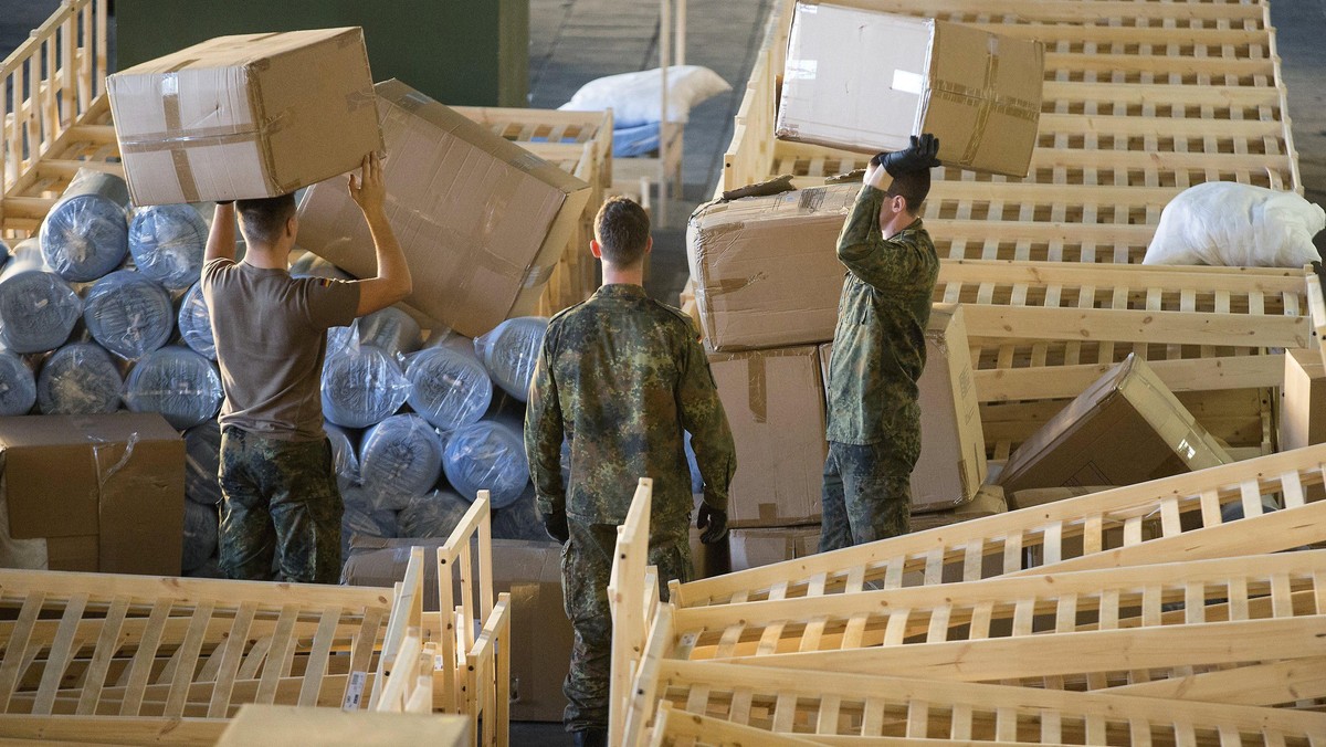 German armed forces Bundeswehr soldiers set up beds for migrants in the hangar of the former Tempelh