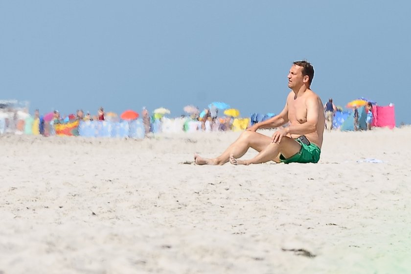 Radosław Sikorski na plaży ćwiczy brzuszki 