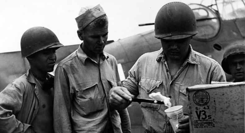 Sailors scoop ice cream delivered by a Grumman F6F Hellcat, seen in the background.US Navy Reserve Lt. Junior Grade Wayne Miller/Naval History and Heritage Command National Archives