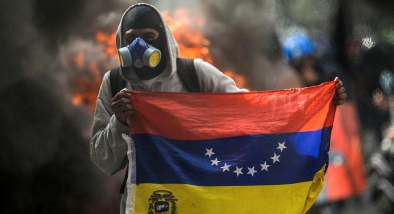 A hooded demonstrator protests against the government of President Nicolas Maduro in Caracas on May 31, 2017
