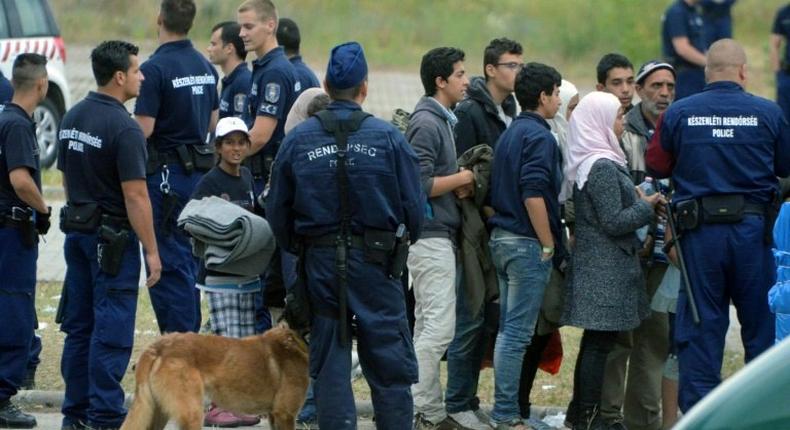 Asylum-seekers wait to board a bus at their temporary Hungarian home of Roszke on the Hungarian-Serbian border in June 2015