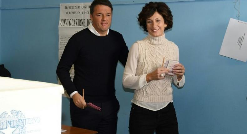 Italy's Prime Minister Matteo Renzi (L) and his wife Agnese Landini vote for a referendum on constitutional reforms, on December 4, 2016 at a polling station in Florence