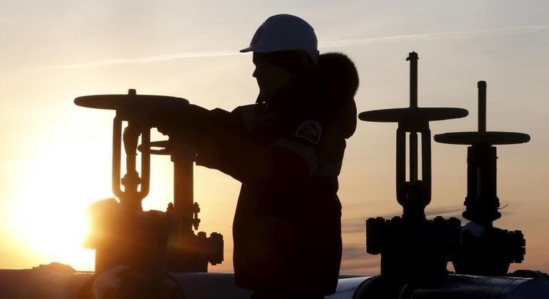 Worker checks valve of oil pipe at Lukoil company owned Imilorskoye oil field outside West Siberian city of Kogalym