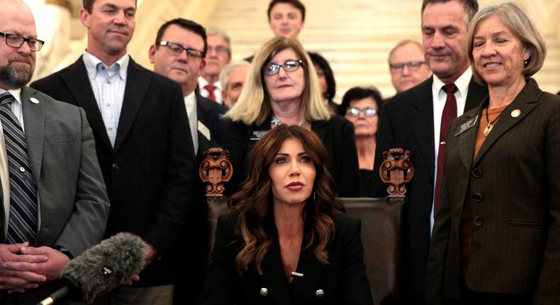 South Dakota Gov. Kristi Noem signs a bill Thursday, Feb. 3, 2022, at the state Capitol in Pierre, S.D., that will ban transgender women and girls from playing in school sports leagues that match their gender identity.