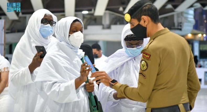 Un membre de la police saoudienne vérifie les détails de la vaccination des pèlerins sur leur smartphone, à la Grande Mosquée, dans la ville sainte de La Mecque, en Arabie saoudite, le 17 octobre 2021 SAUDI PRESS AGENCY