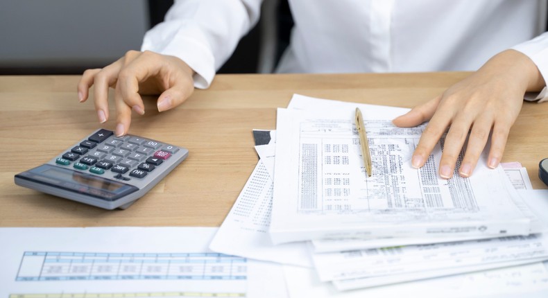 A stock image shows an accountant calculating a paycheck.