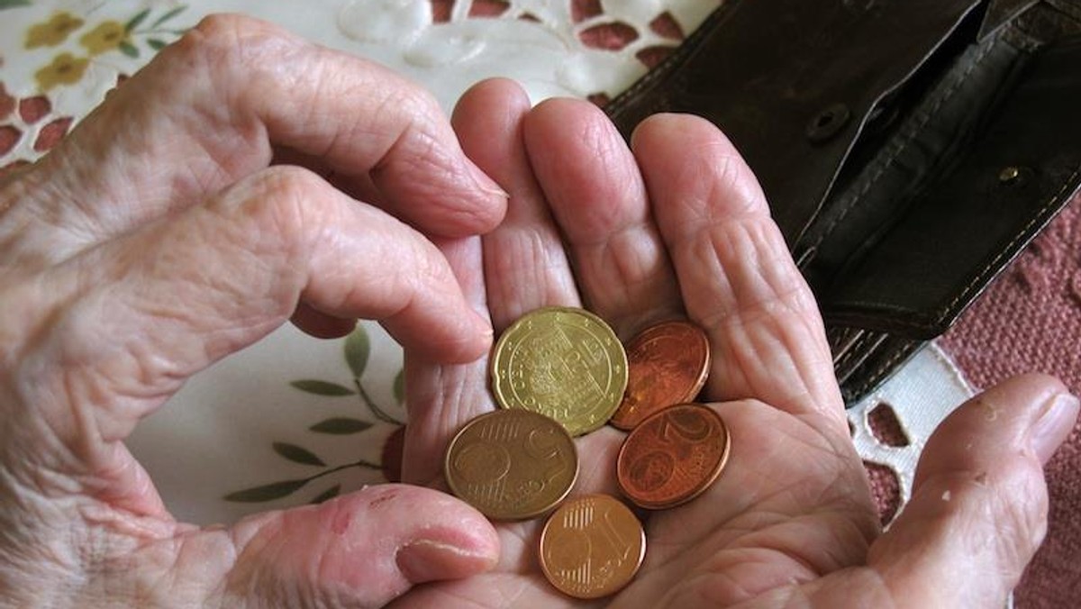 Old woman holds coins