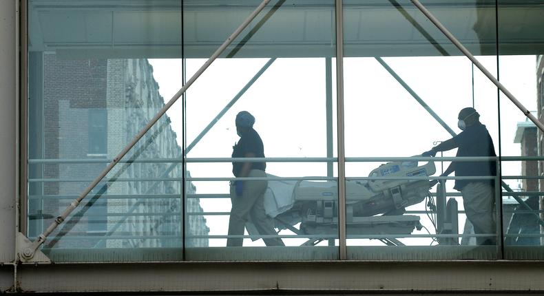 Medical staff move a patient on a gurney across the skyway at Mt. Sinai Morningside Hospital on May 18, 2020 in New York City.