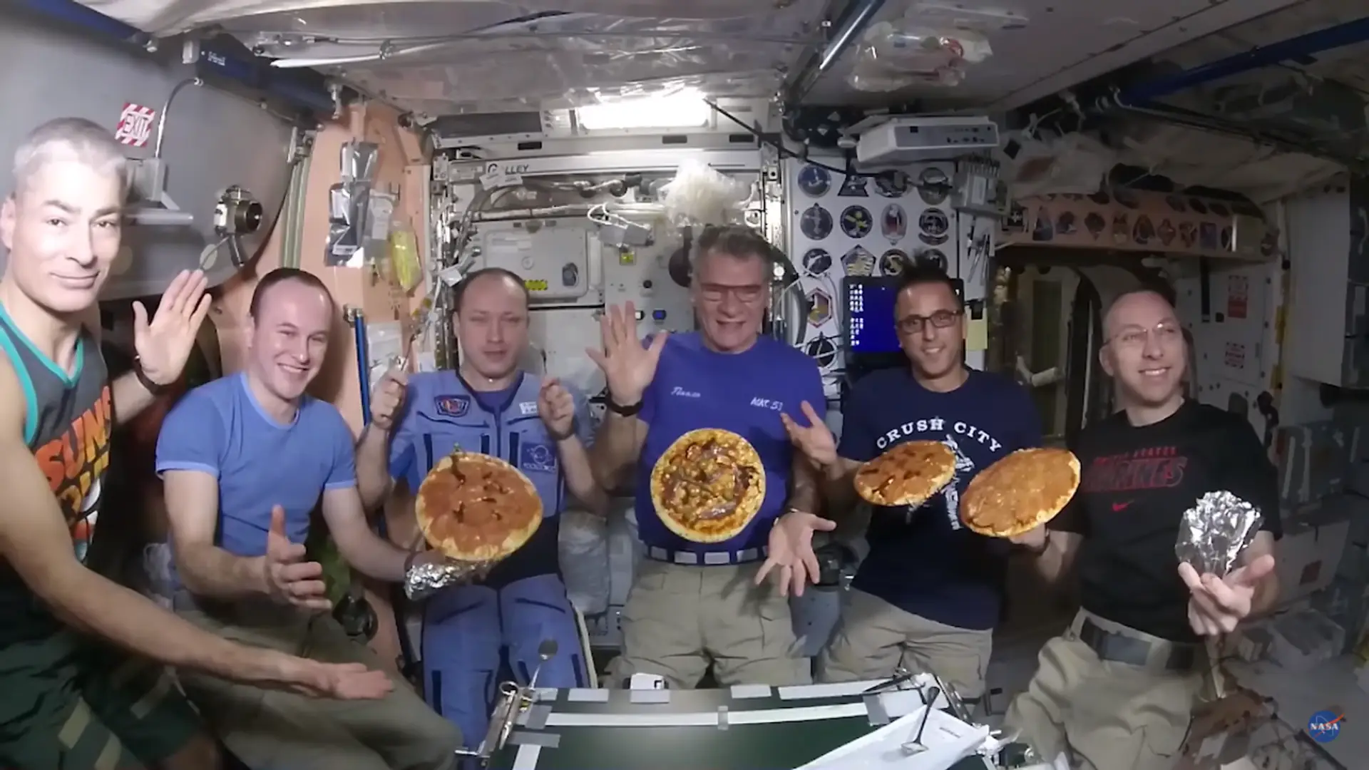 Pizza party w kosmosie. Astronauci bawią się lewitującymi plackami