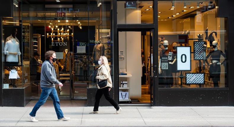 People walk outside the Eton and Wolford stores on the Upper East Side amid the coronavirus pandemic on March 23, 2021 in New York City.
