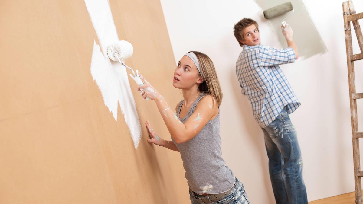 Home improvement: Young couple painting wall 