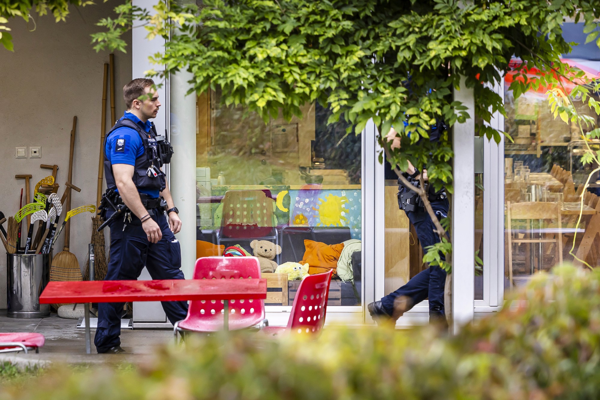Policajti počas zásahu pred denným centrom po tom, čo muž napadol a zranil tri malé deti.