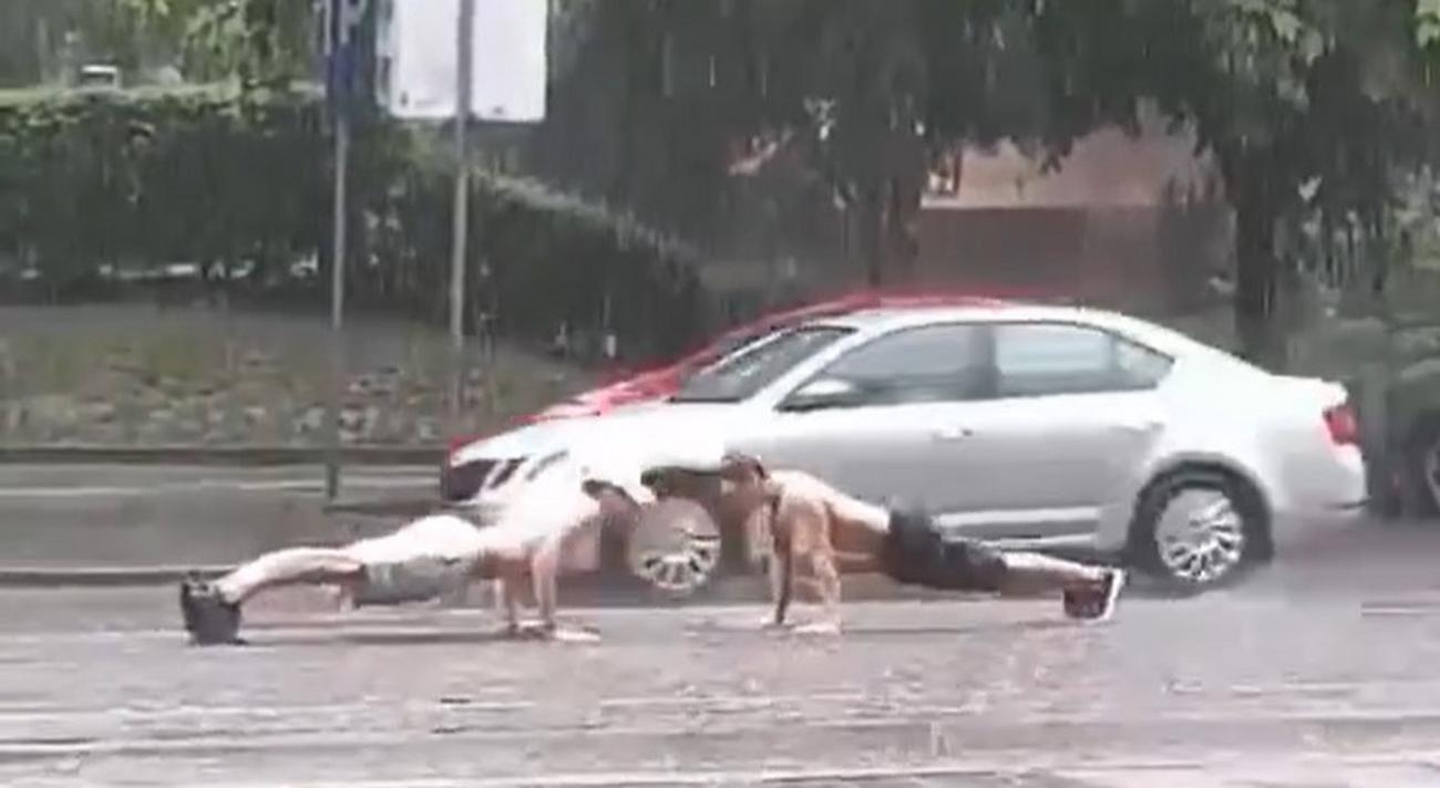 Zwei Männer üben mitten auf der Straße im Zentrum von Belgrad, während der Regen wie ein Kabel herunterströmt