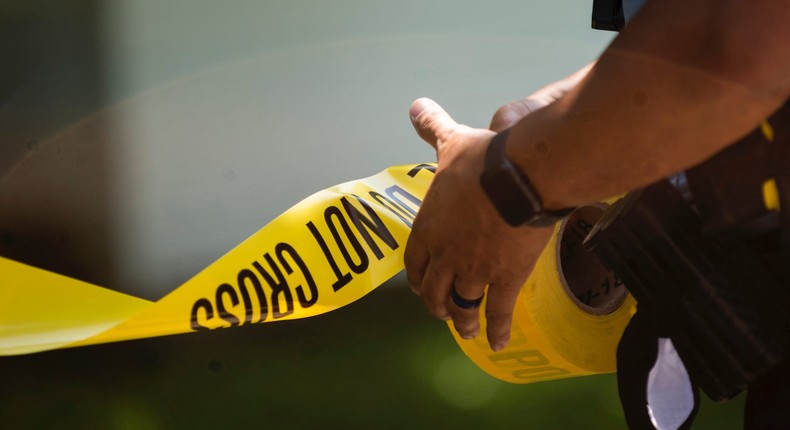 A Minneapolis Police officers unrolls caution tape at a crime scene on June 16, 2020 in Minneapolis, Minnesota.
