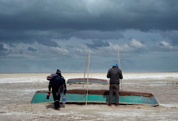 Fishermen and their boats are seen where slight water recovery is observed at Poopo Lake