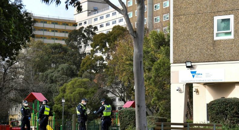 Police stand guard outside a public housing estate locked down in Melbourne due to a spike in coronavirus cases