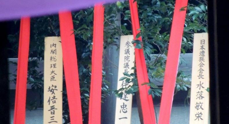 A wooden plaque (L) showing the name of Japanese Prime Minister Shinzo Abe is seen with a masakaki tree that he sent as an offering to the controversial Yasukuni Shrine in Tokyo on October 17, 2016