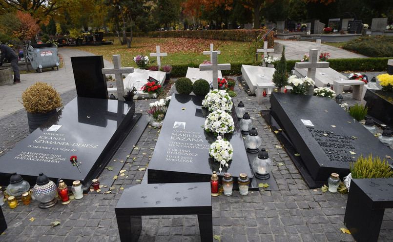 W kwaterze smoleńskiej na warszawskich Powązkach znajdują się nagrobki 28 osób. Są to: gen. Andrzej Błasik, gen. Franciszek Gągor, Grażyna Gęsicka, gen. Kazimierz Gilarski, Przemysław Gosiewski, ppłk Robert Grzywna, Mariusz Handzlik, ks. Roman Indrzejczyk, kpt. Paweł Janeczek, Dariusz Jankowski, Natalia Januszko, Mariusz Kazana, Janusz Krupski, Wojciech Lubiński, Barbara Maciejczyk, Barbara Mamińska, Stefan Melak, ppor. Andrzej Michalak, mjr Dariusz Michałowski, Stanisław Mikke, por. Piotr Nosek, Andrzej Przewoźnik, Sławomir Skrzypek, Władysław Stasiak, ppor. Jacek Surówka, Aleksander Szczygło, Jolanta Szymanek-Deresz i Izabela Tomaszewska. W monument wkomponowana jest również tablica przykrywająca urnę z prochami szczątków odnalezionych na miejscu katastrofy po zakończeniu pogrzebów. Zawiera prochy 12 osób.