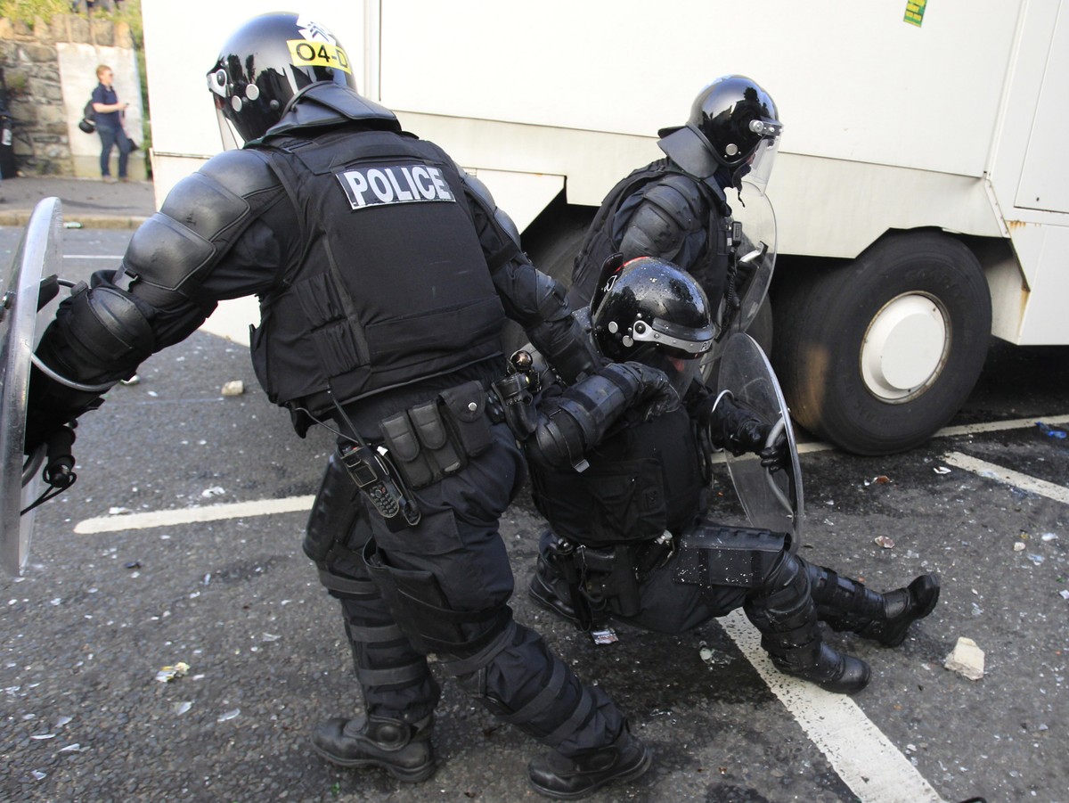 Zamieszki w Belfaście. Policjanci odciągają rannego kolegę