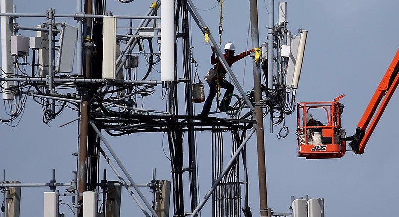 A worker climbs on a cellular communication tower on March 6, 2014 in Oakland, California.