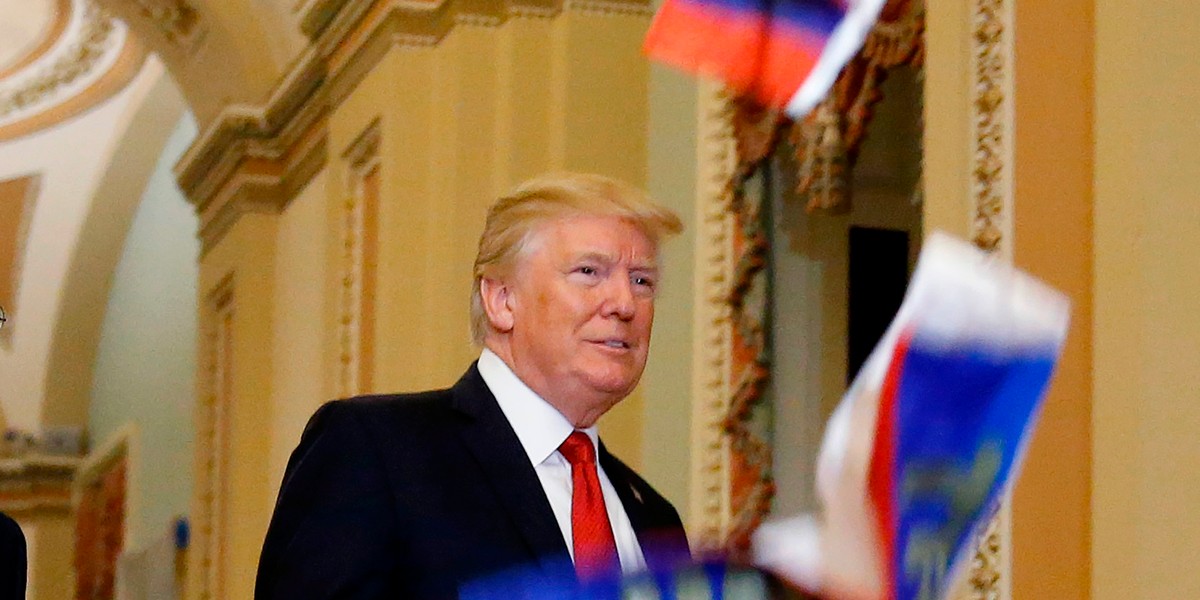 Protester throws Russian flags at Trump as he walks through the Senate