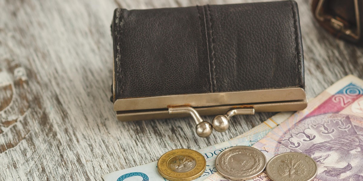 Polish zloty with little wallets on the old wooden background