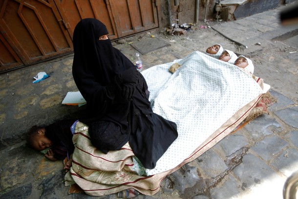 A woman begs for money along a street in the old market in the historic city of Sanaa