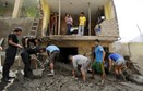 People remove mud and rocks after a massive landslide in Chosica