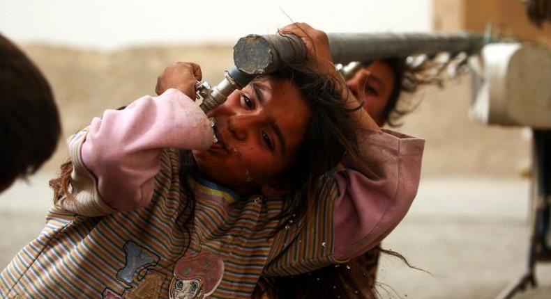 Children who have fled the Islamic State group bastion of Raqa drink from water taps at a camp for the displaced around 25 kilometres (15 miles) from the city on May 10, 2017