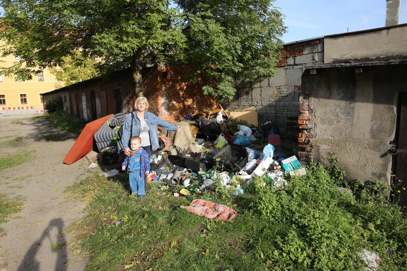 Kobieta z dzieckiem przy śmieciach