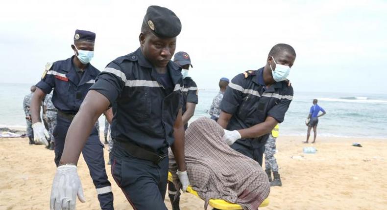 Des sauveteurs portent le corps d'une victime après le naufrage d'une embarcation, le 24 juillet 2023 sur la plage de Ouakam, à Dakar, au Sénégal - AFP SEYLLOU