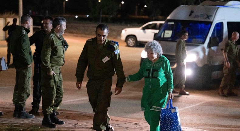 Ruth Munder, a released Israeli hostage, walks with an Israeli soldier shortly after her arrival in Israel on Friday, Nov. 24, 2023.IDF via AP