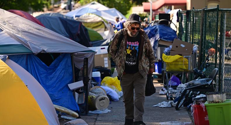 A man walks past a homeless encampment in Denver, Colorado.Helen H. Richardson/MediaNews Group/The Denver Post via Getty Images