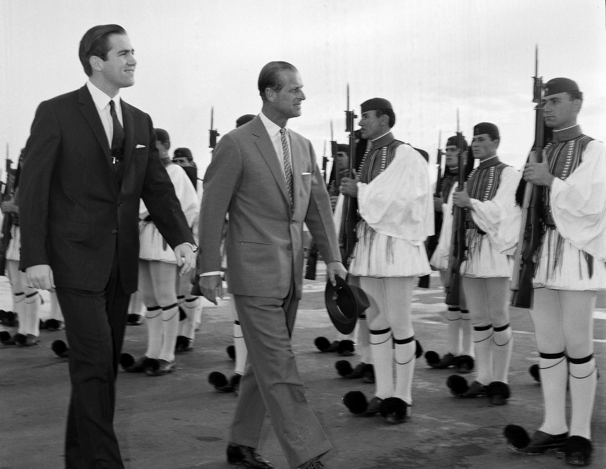 Na archívnej snímke z 25. marca 1965 grécky kráľ Konštantín II. (vľavo) a britský princ Filip počas prehliadky čestnej stráže na letisku v Aténach.