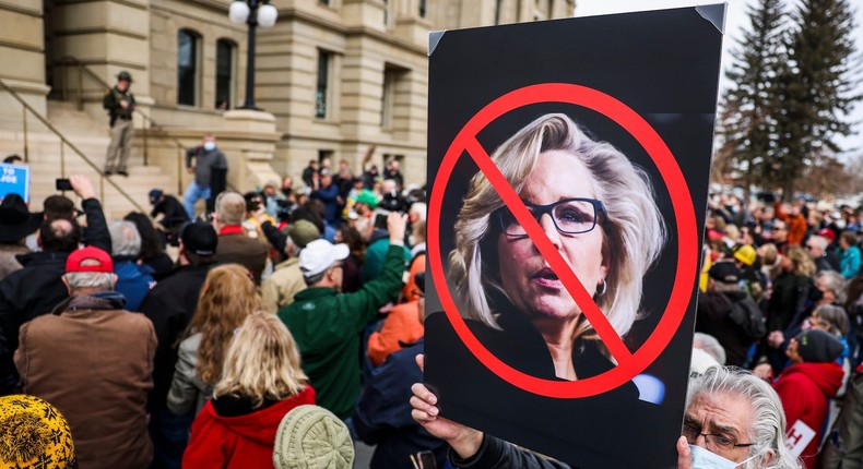 A man holds up a sign against Rep. Liz Cheney (R-WY) as Rep. Matt Gaetz (R-FL) speaks to a crowd during a rally against her on January 28, 2021 in Cheyenne, Wyoming.
