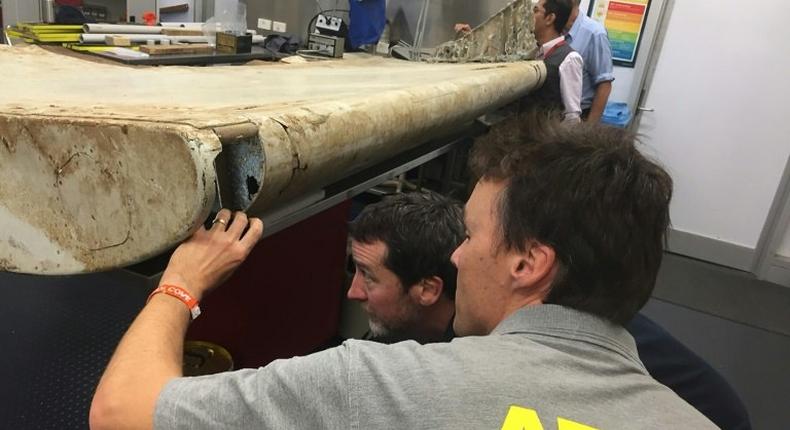 Aviation officials inspect debris from the doomed airliner MH370