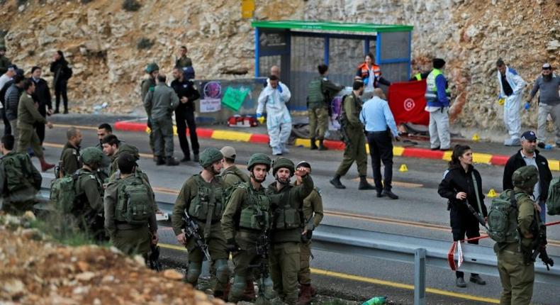 Israeli forces and forensic experts inspect the site of a Palestinian drive-by shooting in the West Bank on December 13, 2018
