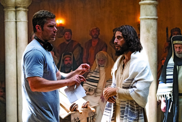 STARS OF THE CHRISTIAN SCREEN Creator and director Dallas Jenkins and star Jonathan Roumie on the set of The Chosen; and Jesus and the disciples in a scene from the series, which has garnered more than 110 million viewers worldwide.