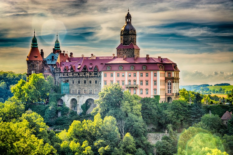 4. Książ. Historia Zamku Książ odzwierciedla historię tej części Europy, gdzie mieszały się wpływy polskie, niemieckie i czeskie. Kompleks zamkowy w Książu i pobliski teren jest jednym z największych w Polsce – ustępuje pierwszeństwa jedynie Wawelowi i Malborkowi. Co ciekawe, pod obecną nazwą występuje dopiero od niespełna siedemdziesięciu lat. Budowla robi niesamowite wrażenie z zewnątrz, ale jej stylowe wnętrze ze słynną Salą Maksymiliana, też stanowi prawdziwą estetyczną ucztę dla turystów. Pomysłowe trasy zwiedzania, ekspozycja wałbrzyskiej porcelany, muzeum, hotel, pobliska stadnina koni i Palmiarnia Lubiechowska, której częścią ścian jest materiał pochodzący z wulkanu Etna, tworzą cudownie zróżnicowany charakter tego miejsca.