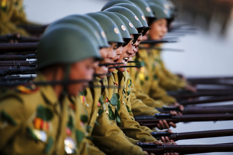 Soldiers shout slogans as they march past a stand with North Korean leader Kim Jong Un and other officials.