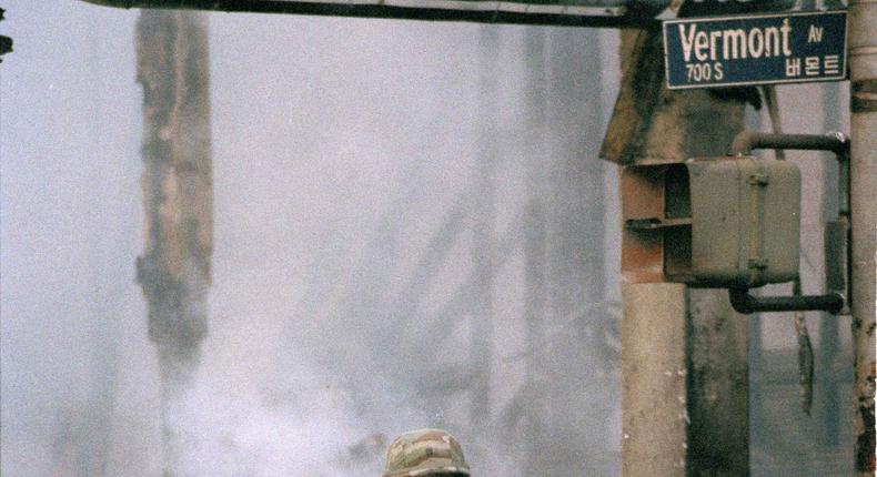 A National Guardsman stands next to a burned out business area during the second day of rioting in Los Angeles on April 30, 1992.