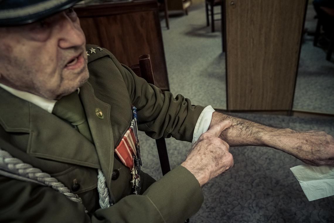 Kapitan Kulig pokazuje numer nadany mu w obozie w Auschwitz