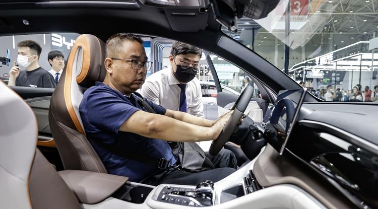Érdeklődő tekinti meg az új BYD modellt egy wuhani autóshown