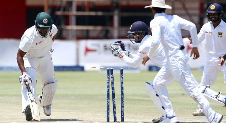 Zimbabwe's batsman Hamilton Masakadza (left) survives a run out attempt by wicketkeeper Kusal Janith Perera during a Test match in Harare, on November 2, 2016